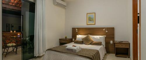 a bedroom with a large bed with a wooden headboard at Pousada Lua e Mar in Ilhéus