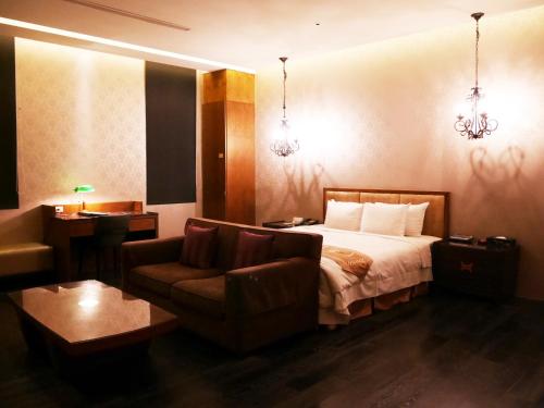 a hotel room with a bed and a couch at Lanshy Motel in Taichung