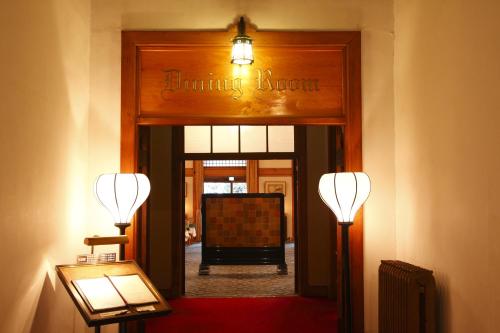 a hallway with two lights and a sign that reads alumni hall at Nara Hotel in Nara