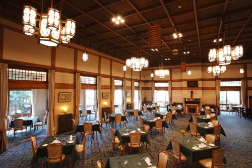 Nara Hotel في نارا: غرفة طعام بها طاولات وكراسي وثريات