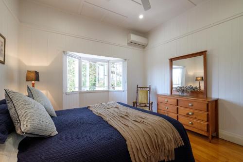 Central Cottage في بريزبين: غرفة نوم بسرير وخزانة ومرآة