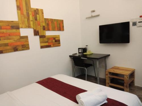 a bedroom with a bed and a desk and a television at The Verve Hotel PJ Damansara in Petaling Jaya