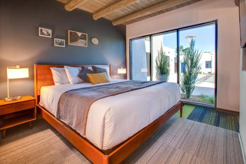 a bedroom with a large bed and a large window at El Vado Motel in Albuquerque