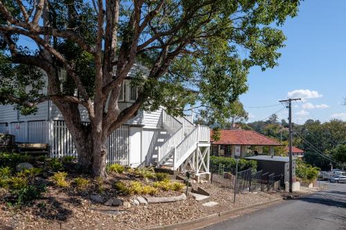 a house with a tree on the side of the street at Central Cottage in Brisbane