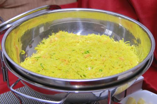 a bowl full of shredded cheese on a stove at Galaxy Grand Hotel in Nuwara Eliya