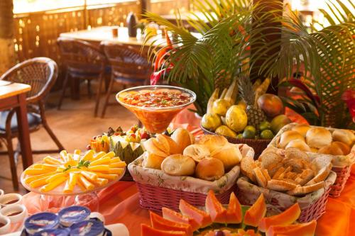 a table topped with baskets of bread and other foods at Pousada Praia das Ondas - Pé na areia in Itacimirim