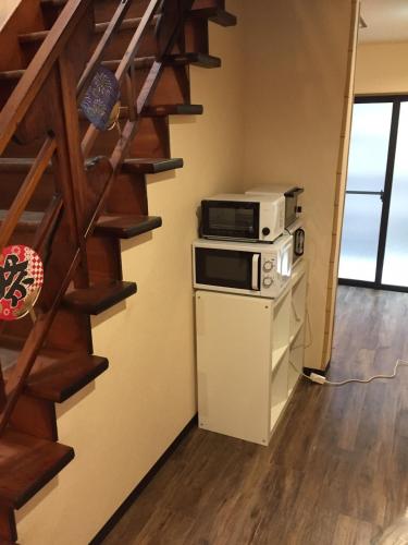 a kitchen with a microwave on top of a stove at Ryokan Ichinao in Tokyo