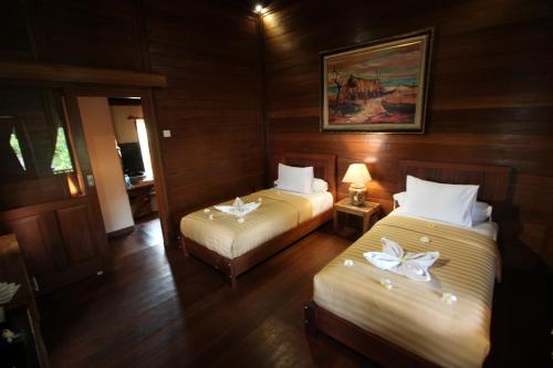 
a hotel room with two beds and two lamps at Mina Tanjung Hotel in Tanjung
