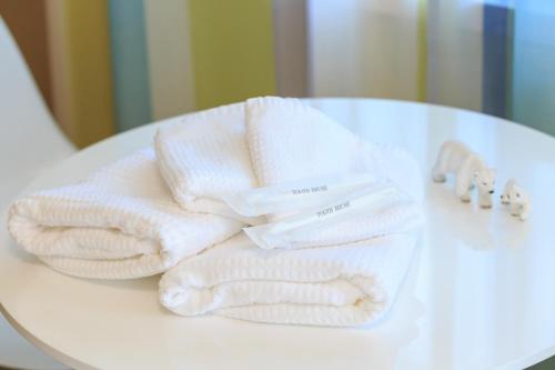 a pile of towels sitting on top of a table at Kulton Moct Kenroku in Kanazawa