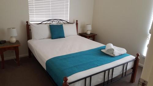 a bedroom with a bed with a towel on it at Sea Star Apartments in Airlie Beach
