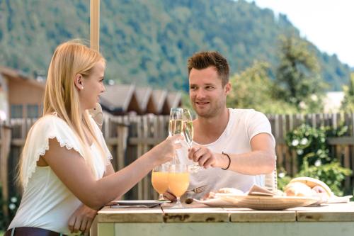 a man and woman sitting at a table drinking wine at Hotel Metzgerwirt in Sankt Veit im Pongau