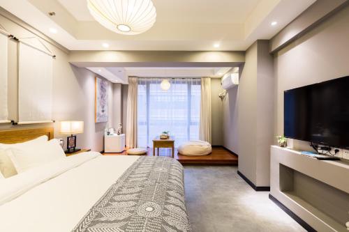a bedroom with a large bed and a flat screen tv at Chongqing Ouranjian Lake View Guesthouse in Chongqing