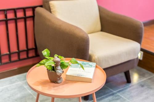a coffee table with a book and a plant on it at Chongqing Ouranjian Lake View Guesthouse in Chongqing