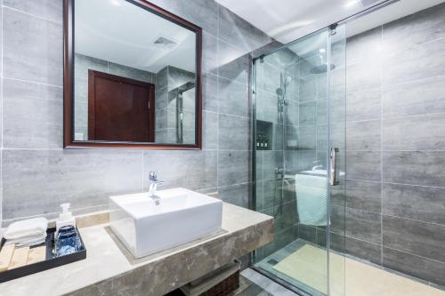 a bathroom with a sink and a glass shower at Chongqing Ouranjian Lake View Guesthouse in Chongqing