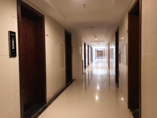 an empty hallway of a building with doors and a hallway at Chongqing Ouranjian Lake View Guesthouse in Chongqing