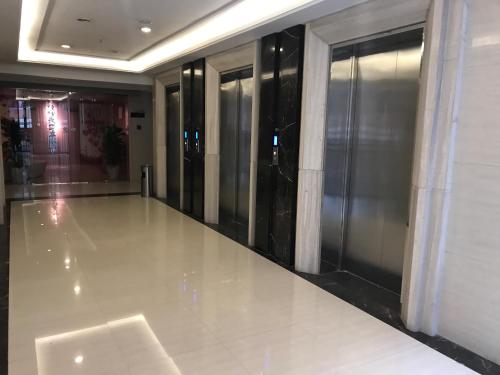 a hallway of a building with glass doors at Chongqing Ouranjian Lake View Guesthouse in Chongqing