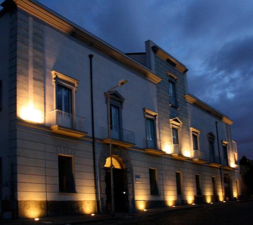 a large white building with lights on it at night at Villa Avellino Historic Residence in Pozzuoli