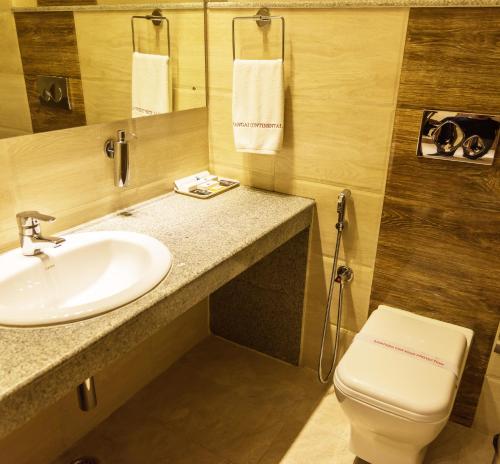 a bathroom with a sink and a toilet at Sangai Continental (The Boutique Hotel) in Imphal