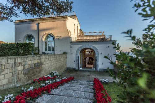 a house with red flowers in front of it at Villa Avellino Historic Residence in Pozzuoli