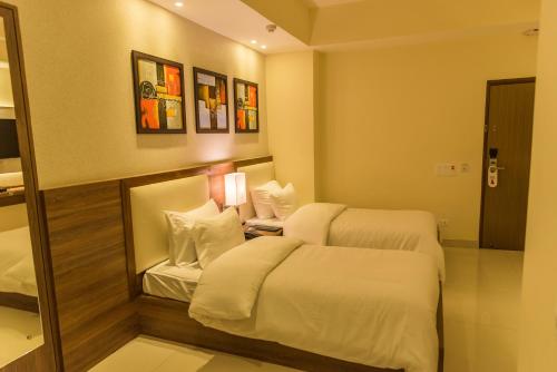 a hotel room with two beds and a mirror at Sangai Continental (The Boutique Hotel) in Imphal