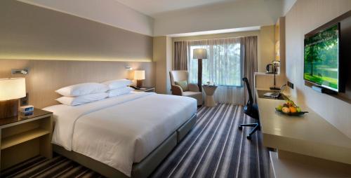 a hotel room with a large bed and a desk at The Saujana Kuala Lumpur in Subang Jaya