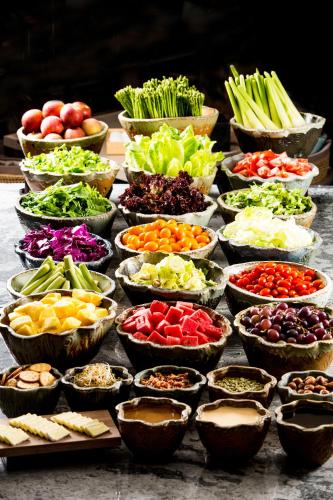 a table full of bowls of different types of vegetables at 礁溪晶泉丰旅 Wellspring by Silks Jiaoxi in Jiaoxi