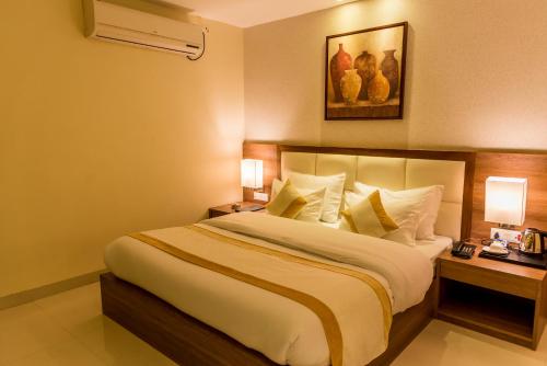 a hotel room with a large bed with two night stands at Sangai Continental (The Boutique Hotel) in Imphal