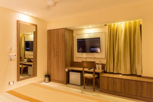 a hotel room with a desk and a television in a room at Sangai Continental (The Boutique Hotel) in Imphal