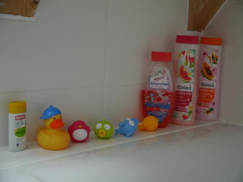 a shelf with a bunch of detergents and rubber ducks at Ferienwohnung im Neubauernweg 3 in Hoppegarten