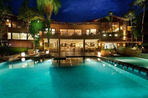 a swimming pool in front of a building at night at Loi Suites Iguazu Hotel in Puerto Iguazú