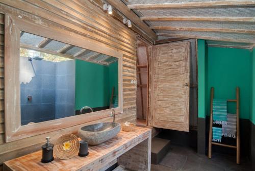baño con lavabo y pared verde en Gili Meno Escape - Adults Only en Gili Meno