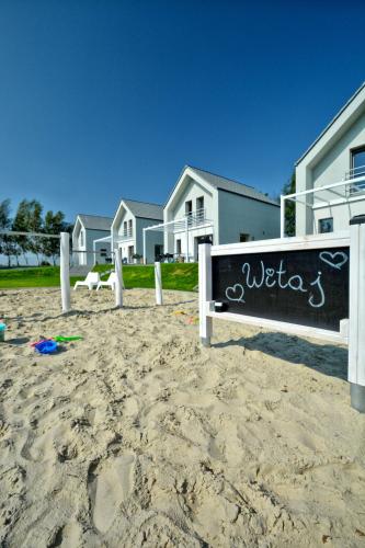 a sign on the beach in front of some houses at KOMFORTOWE DOMKI Brzozowa Przystań nad morzem we Władysławowie in Władysławowo