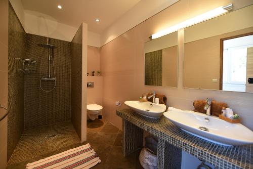 Un baño con dos lavabos y una ducha. en Valinco Locations OLMETO PLAGE, en Olmeto