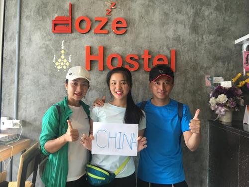 a group of three people holding a sign that says hope hospital at Doze Hostel in Chiang Mai