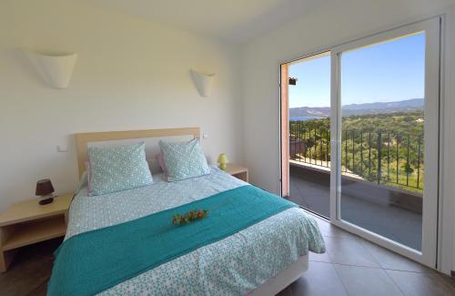 Un dormitorio con una cama y una ventana grande. en Valinco Locations OLMETO PLAGE, en Olmeto