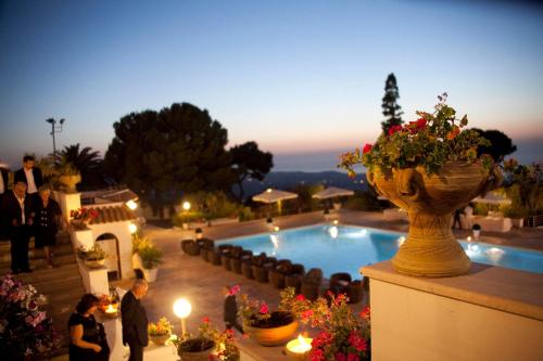 a group of people standing around a pool with a vase of flowers at 501 Hotel in Vibo Valentia