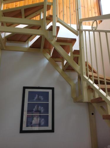 a wooden staircase with a picture on a wall at King Apartman in Sárvár