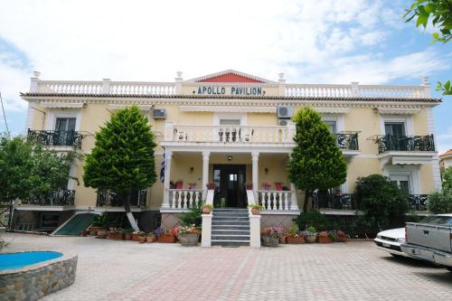 a large white building with a balcony and stairs at Apollo Pavilion Apartments in Mirina