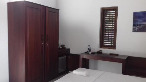 a bedroom with a bed and a desk and a cabinet at Villa A50 in Negombo
