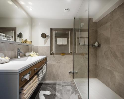 a bathroom with a shower and a sink at Aktiv- & Gesundheitsresort das GXUND - Thermeneintritt inklusive in Bad Hofgastein