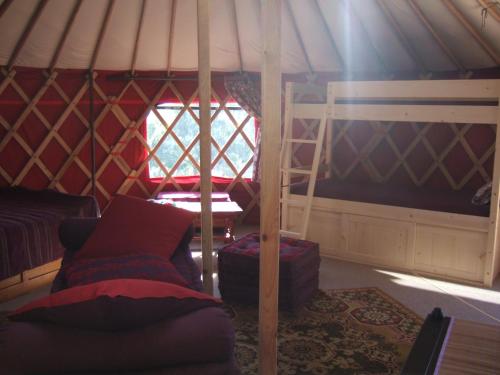 a room with a bed and a ladder in a yurt at Domaine du Rocher St-Loup in Vif