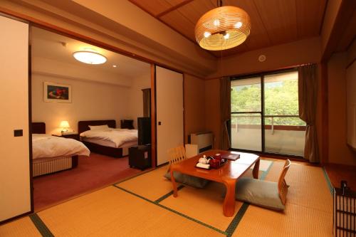 - une chambre avec 2 lits et une table dans l'établissement Le Vert Zao, à Zao Onsen
