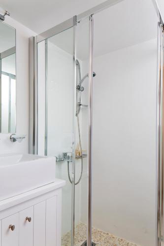 a bathroom with a shower and a sink at Villa Del Sol Mykonos in Ornos