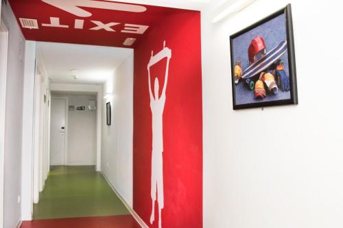 a hallway with a red wall with a painting of a fire hydrant at Sant Jordi Hostels Sagrada Familia in Barcelona
