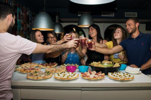 a group of people standing around a table with food at Sant Jordi Hostels Sagrada Familia in Barcelona