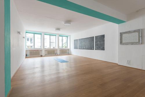 um quarto vazio com paredes brancas e pisos de madeira em Apartment in der Yogaschule em Colônia