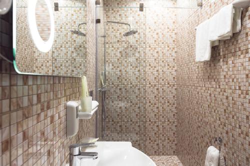 W łazience znajduje się toaleta, umywalka i lustro. w obiekcie Historic Hotel Central w Irkucku