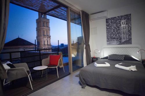 ein Schlafzimmer mit einem Bett und einem großen Fenster mit einem Turm in der Unterkunft Studiolo Belvedere in Split
