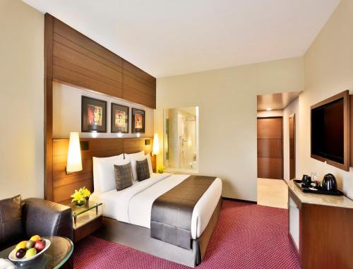 a hotel room with a bed and a couch at Radisson Blu Atria Bengaluru in Bangalore