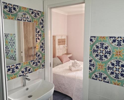 uma casa de banho com um lavatório e um quarto com uma cama em A casa di Noemi em Pizzo